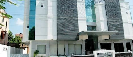 A modern building with a flat roof, large windows, and a gated entrance.