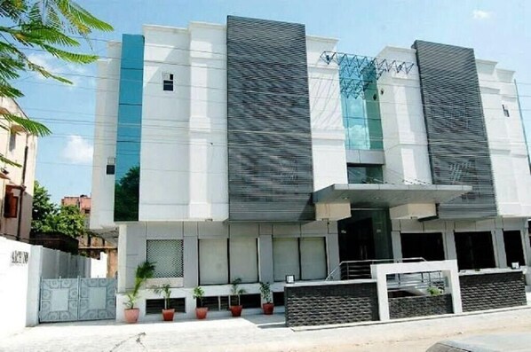 A modern building with a flat roof, large windows, and a gated entrance. - Hotel Arch Inn (Jaipur)