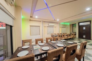 A conference room with a long table, multiple chairs, and a tiled floor. - Hotel Arch Inn (Jaipur)