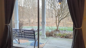 A room with a large window, a bench outside, and a birdhouse on the window sill. - Mid-Term Rental Furnished 2BR/2BA Condo in Germantown, MD (Germantown)