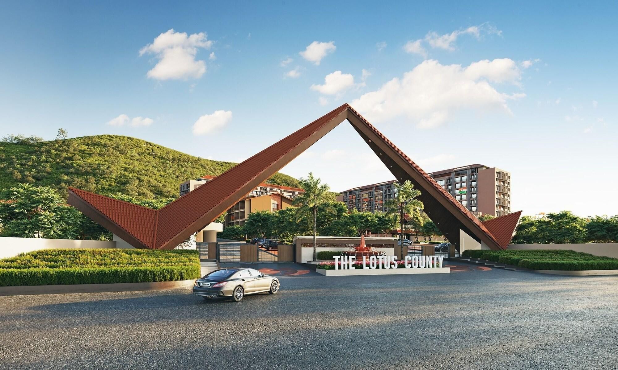A modern building with a unique triangular entrance structure, a car in the foreground, and a sign reading 'THE LOTUS COUNTY'.