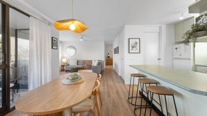 Eine moderne Küche mit Bar, einem Holzespeisetisch und einer Pendelleuchte.