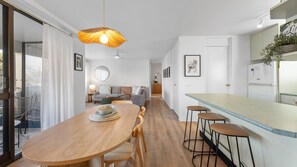 Eine moderne Küche mit Bar, einem Holzespeisetisch und einer Pendelleuchte.