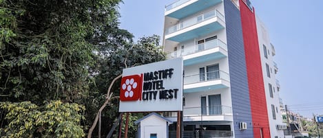 A multi-story building with a sign for 'Mastiff Hotel City West' featuring a logo with four circles.