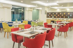A dining area with tables and chairs, air conditioning units, and a wall with beverage dispensers. - Mastiff City Nest Golf Course Extension by Othpl (Gurugram)