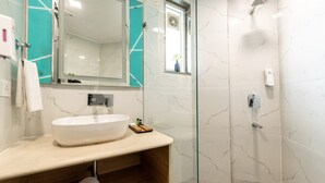 A bathroom with a large white sink, a glass shower enclosure, and a mirror with a teal accent wall. - Mastiff City Nest Golf Course Extension by Othpl (Gurugram)