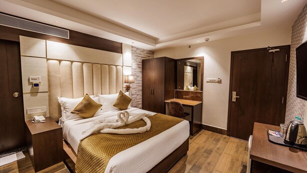 A hotel room with a bed, bedside table, desk, mirror, wardrobe, and a bathroom. - Casa De Katson (Alto de Porvorim)