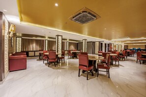 A spacious restaurant with marble flooring, red upholstered chairs, and a warm color scheme. - Casa De Katson (Alto de Porvorim)