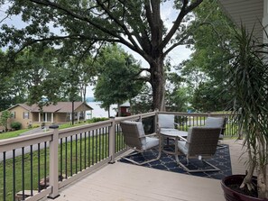 A deck with outdoor furniture, a railing, and a large tree. - 3-bed 2 Bath Pet & Family Friendly Lake view, Fire pit &Games
@LakeItEasyBarkley (Cadiz)