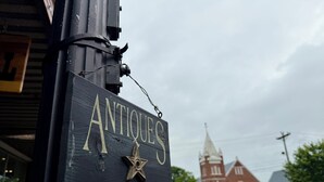 Señal de una tienda de antigüedades con un emblema de estrella.