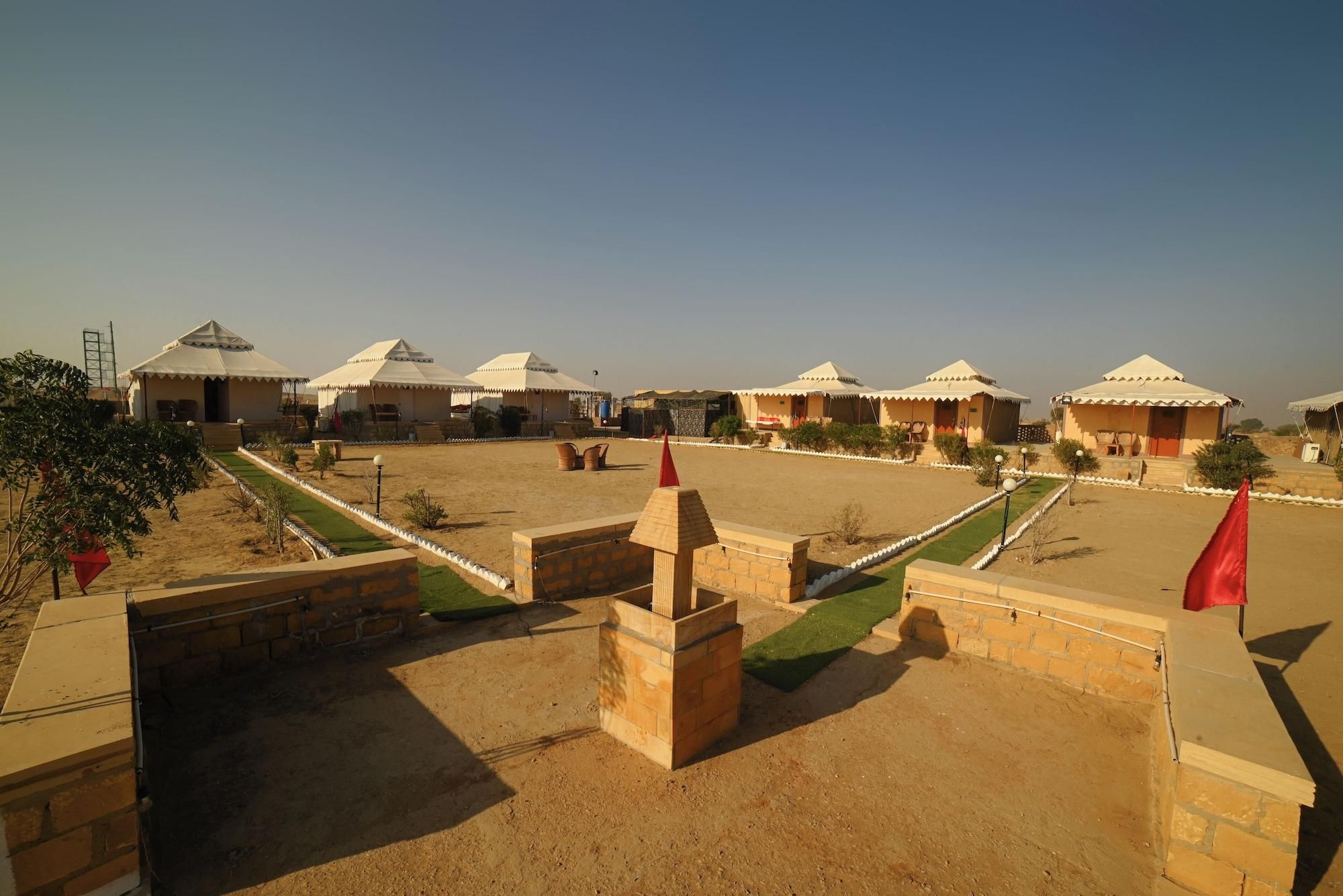 A series of traditional tents with flat roofs, arranged in a row with a central open area.