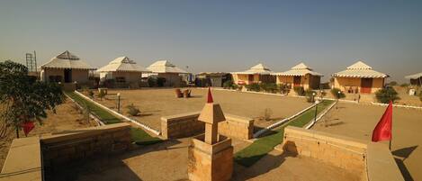 A series of traditional tents with flat roofs, arranged in a row with a central open area.