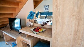 Ein Schlafzimmer mit einem Bett, einem Fernseher, einer Obstplatte und einem Weinglas.