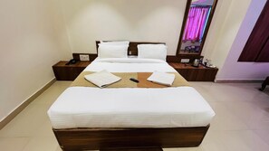 A hotel room with a large bed, bedside tables, a mirror, and a nightstand.