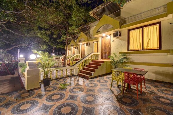 A hotel with a tiled courtyard, a staircase, and a dining area.