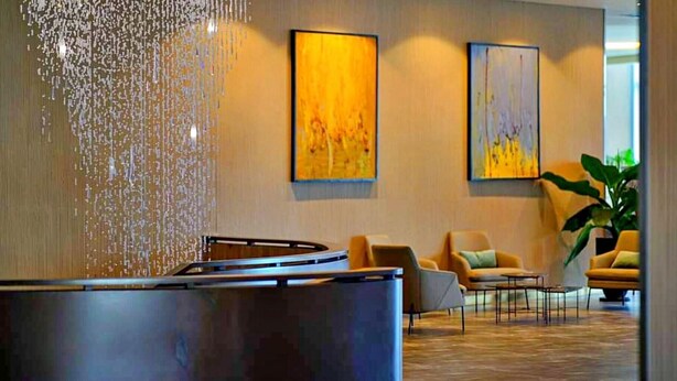 A lobby with a water feature, seating area, and artwork on the walls. - Hanz Business Suite Oceanus Condotel (Bac Nha Trang)
