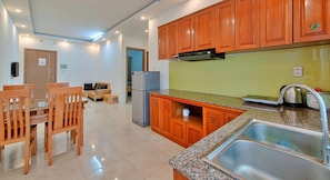 Una cucina moderna con mobili in legno, un piano di lavoro in granito e un lavello in acciaio inossidabile.