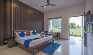 Un dormitorio moderno con una cama grande, un escritorio y vistas a un jardín.