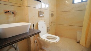 A bathroom with a white sink, a toilet, and a shower. - Shrigo Hotel Rudra Palace (Udaipur)
