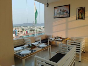 Zona pranzo con vista sulla città, inclusa una bandiera, attraverso un'ampia finestra.