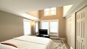 A bedroom with a bed, a television, and a wardrobe.