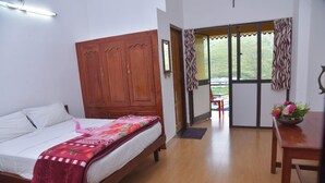 Un dormitorio con cama, armario de madera y vistas al exterior a través de un ventanal.