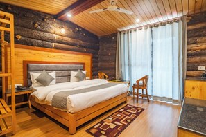 A log cabin-style bedroom with a wooden bed, a desk, and a chair. - Hotel Winterfell Mussoorie (Dehradun)