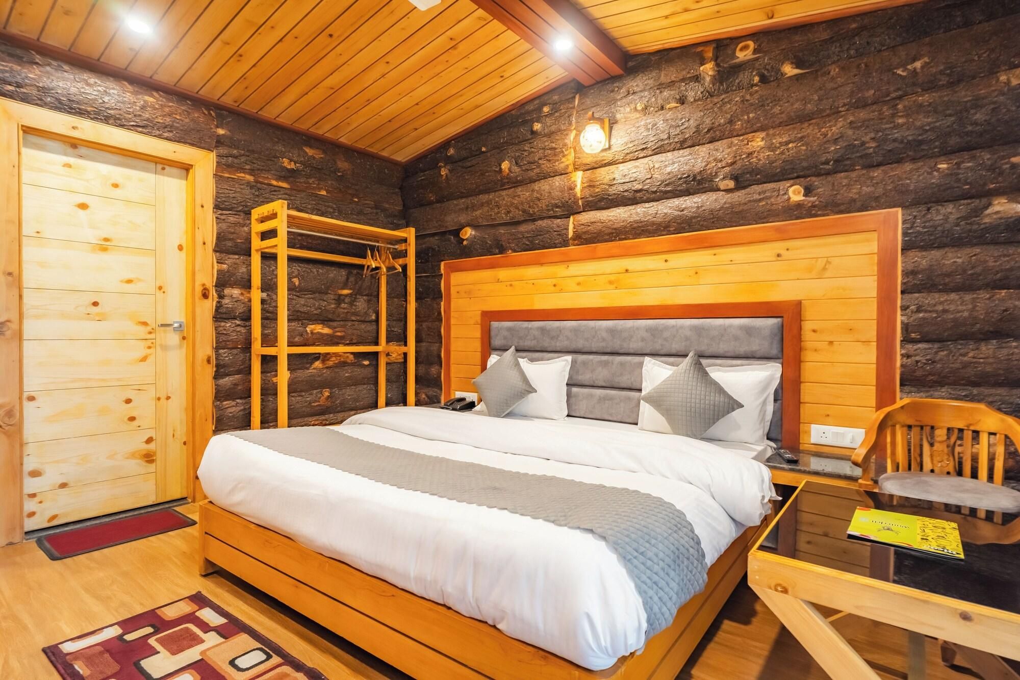 A log cabin bedroom with a wooden bed, a wooden wardrobe, and a small table.