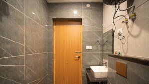 A bathroom with a wooden door, a sink, and a shower area. - Hotel Winterfell Mussoorie (Dehradun)