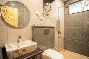 A bathroom with a marble sink, a toilet, a shower, and a mirror. - Hotel Winterfell Mussoorie (Dehradun)