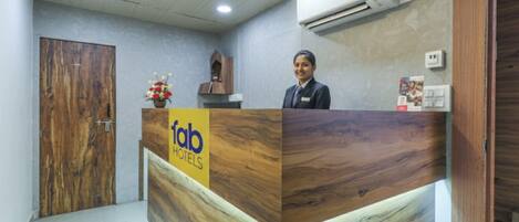 A reception desk with a wooden finish and a sign for 'fab hotels'.