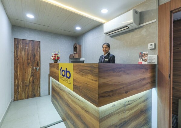 A reception desk with a wooden finish and a sign for 'fab hotels'. - Fabhotel Prime Amazonika Boutique Resort (Arpora)