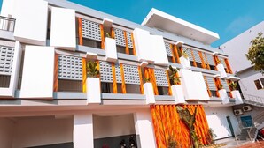 A modern multi-story building with balconies, a staircase, and a covered entrance area. - Ngochoa Hotel (Da Nang Municipality)