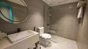 A modern bathroom with a large bathtub, a toilet, and a glass-enclosed shower area. - Al Rayan Hotel (Jeddah)