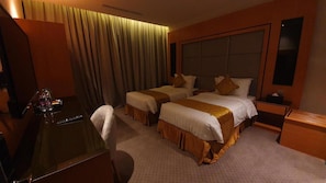 A hotel room with two beds, a desk, a chair, a nightstand, and a mirror. - Al Rayan Hotel (Jeddah)