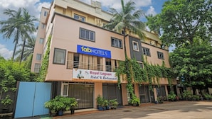 Un bâtiment portant une enseigne indiquant « fabHOTELS » et « Royal Lagoon Hotel & Restaurant », avec une entrée fermée par un portail et des plantes en pot.