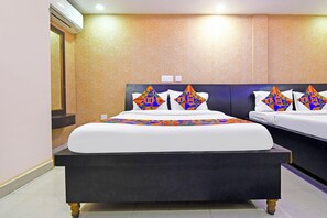 A hotel room with a large bed, a smaller bed, a nightstand, and a wall-mounted air conditioner. - Fabhotel Royal Lagoon (Bhubaneshwar)