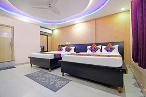 A hotel room with two beds, a ceiling fan, and a modern design.