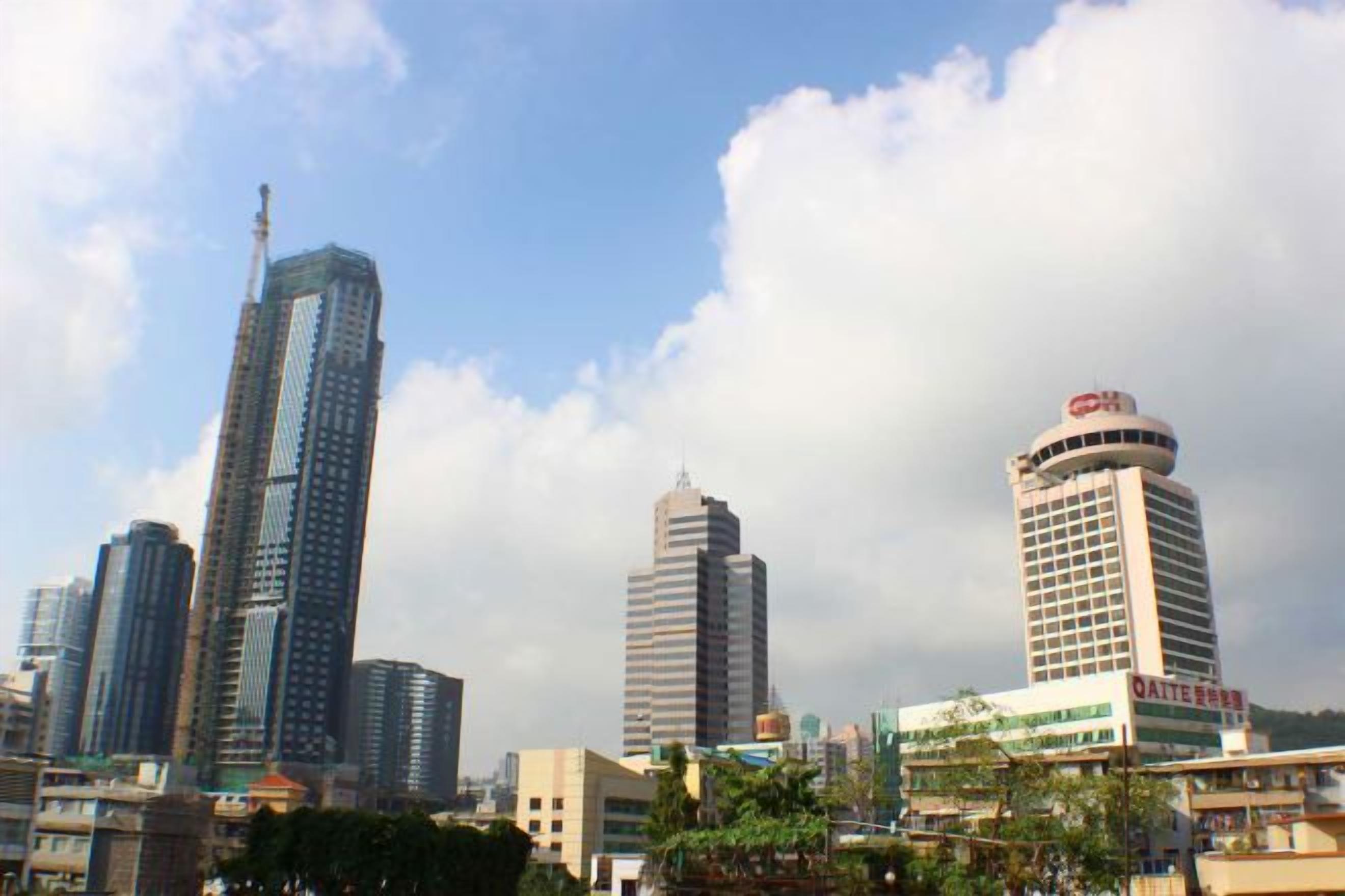 A cityscape with modern high-rise buildings, one with a distinctive curved top.