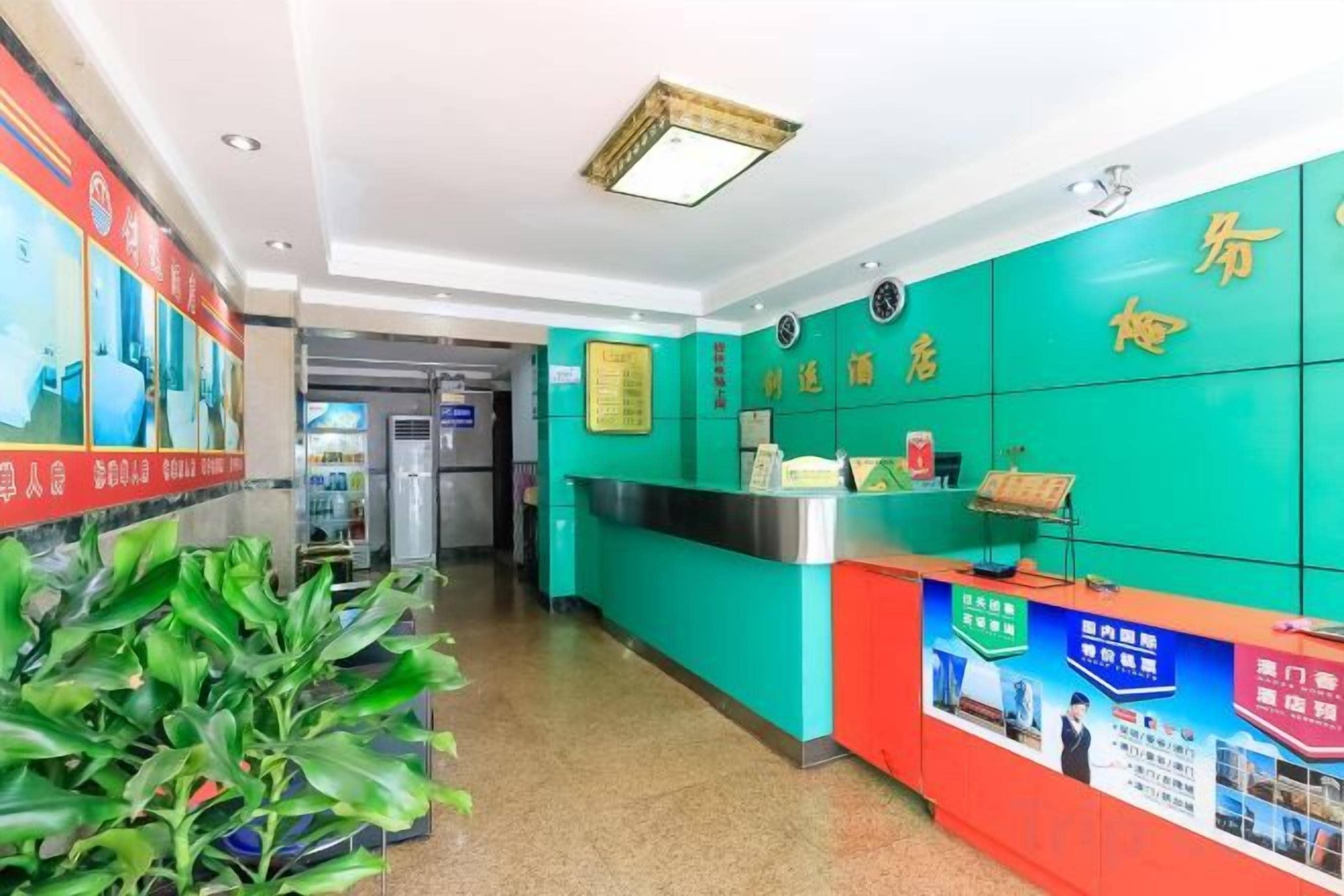 A reception area with a counter, informational posters, and a green wall with text.