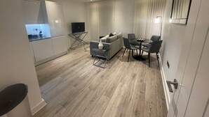 Un salon moderne avec un canapé, une table basse et un téléviseur.