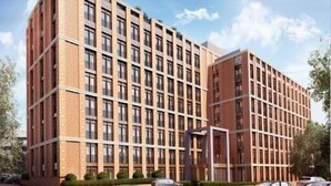 Un immeuble à plusieurs étages, doté d’une façade symétrique, d’une toiture plate et d’une série de fenêtres disposées en réseau.