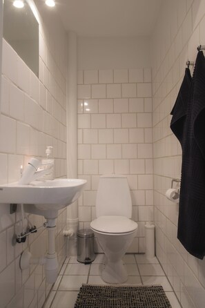 Ein Badezimmer mit Waschbecken, Toilette und Mülleimer.