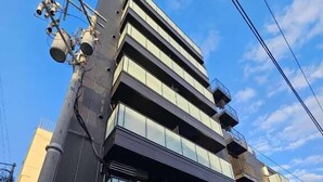 Un edificio de varios pisos con un diseño arquitectónico moderno, que cuenta con amplias ventanas y balcones.