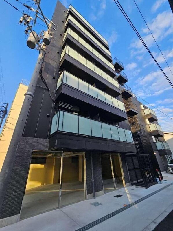 A multi-story building with a modern architectural design, featuring large windows and balconies.