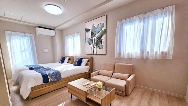 Una habitación de hotel moderna con cama, sofá y mesa de centro.