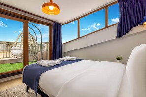 Ein Schlafzimmer mit Bett, Blick zum Himmel, einer Hängematte und einer kleinen Pflanze.
