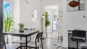 Een moderne keuken met een eettafel, stoelen, een koelkast en een magnetron.