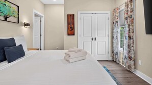 A bedroom with a bed, a door, a painting, and a window with curtains. - Cozy stay in Germantown near Downtown attractions! (Louisville)