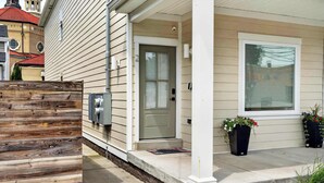 A house with a wooden fence, a front door, a porch, and two flower pots. - Cozy stay in Germantown near Downtown attractions! (Louisville)